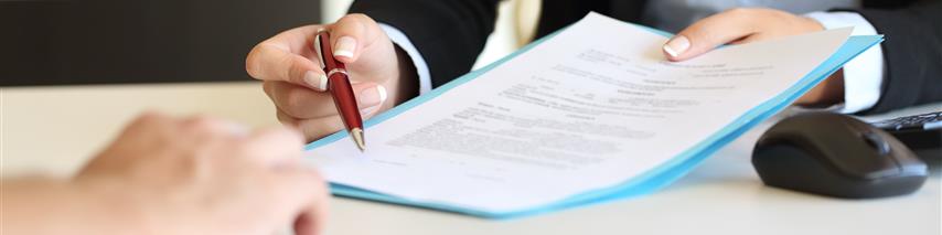 Shows business woman showing customers where to sign on legal documents.